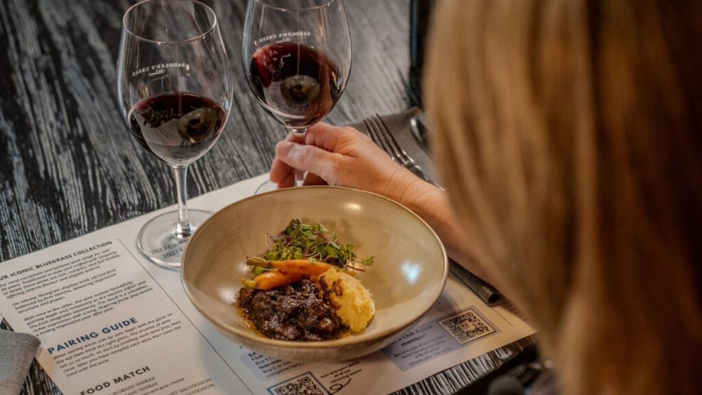 Beef cheek with mash and kale beside two Bluegrass Shiraz pours