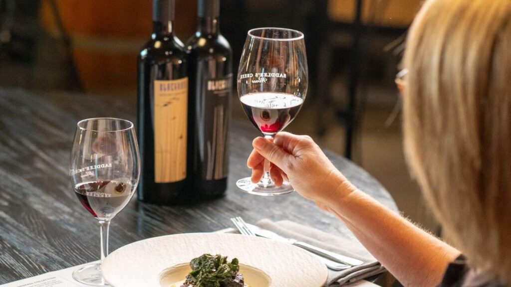 Bluegrass pairing holding up wine glass