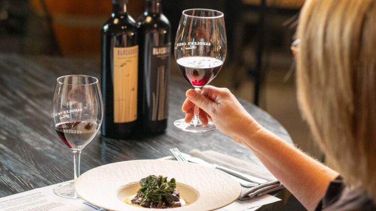 Guest smelling red wine during a seated food and wine pairing