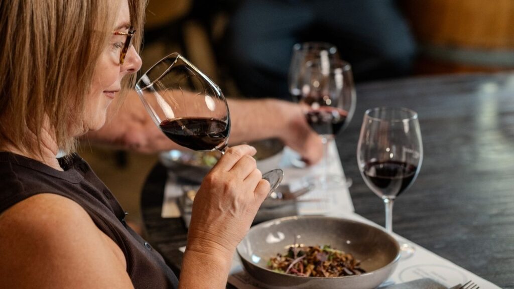 Guest smelling red wine during a seated food and wine pairing