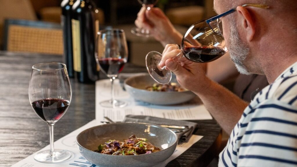 Guests tasting red wine over lunch in the Barrel Room